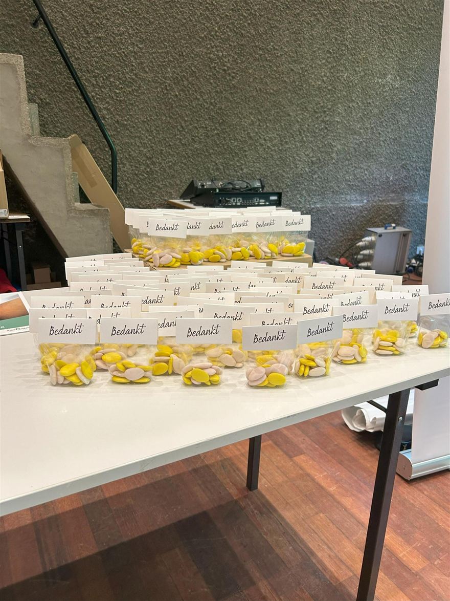 Een tafel vol bedankjes met een geel lintje.